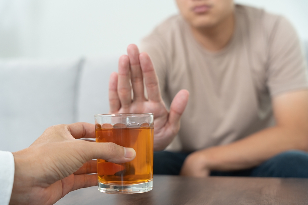 Bărbat refuzând o băutură care dăunează ficatului
