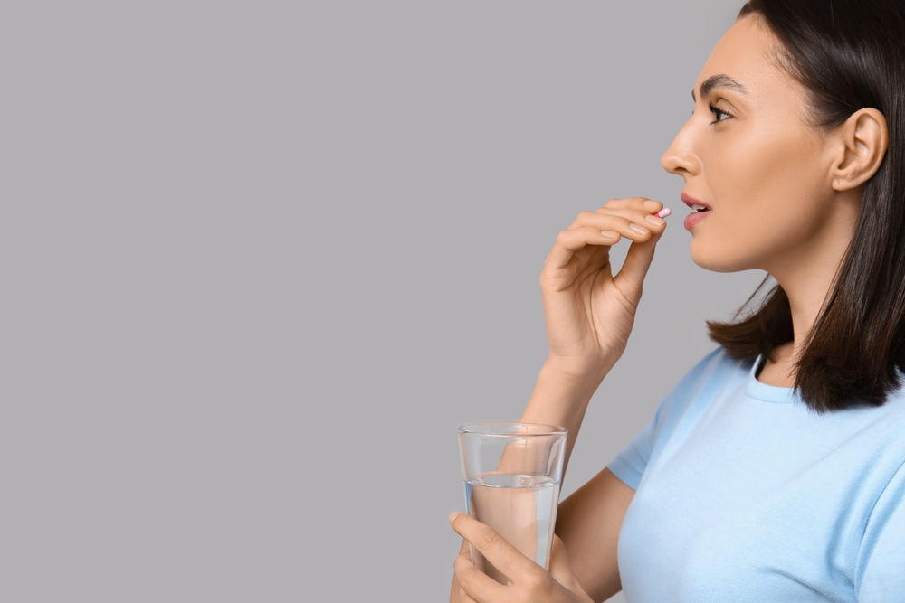  femeie care ia suplimente pentru sănătatea ficatului