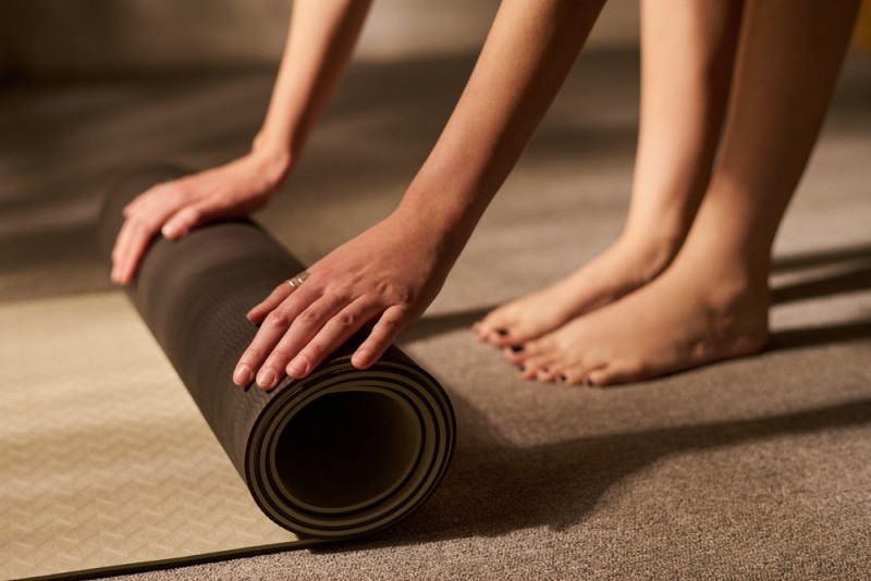 o persoana se pregateste pentru o sedinta de yoga