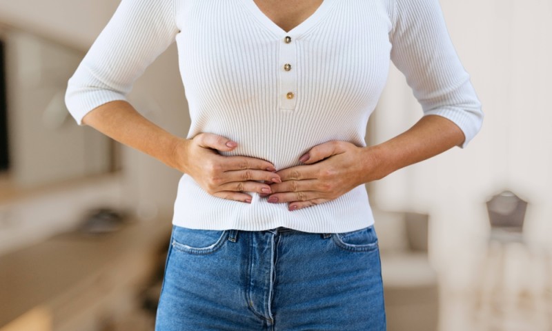 femeie care prezinta semne de disconfort la nivelul abdomenului